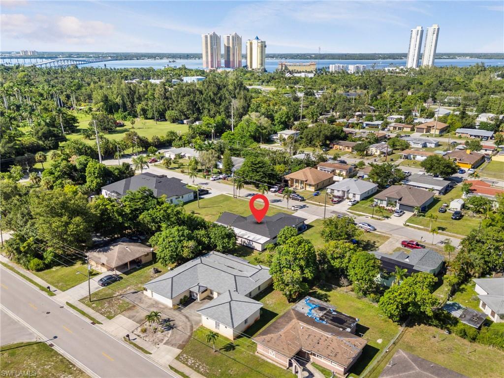 Image 4: Aerial view of residential area featuring a nearby body of water and a notable bridge