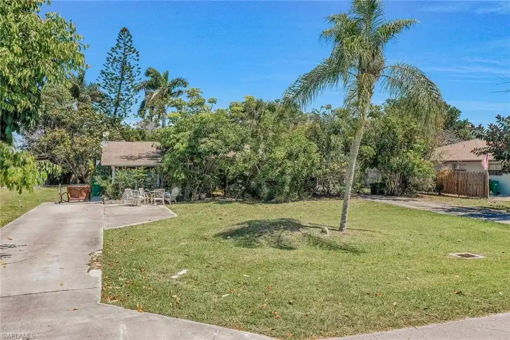 Image 1: View of property hidden behind natural elements featuring a patio