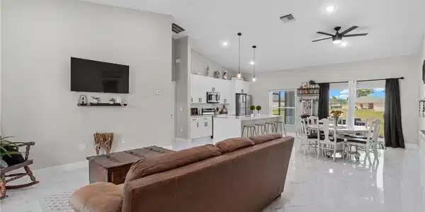 Image 3: Living room with vaulted ceiling, a ceiling fan, recessed lighting, and light marble finish flooring
