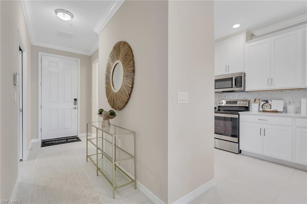 Image 3: Corridor with crown molding and light tile patterned floors