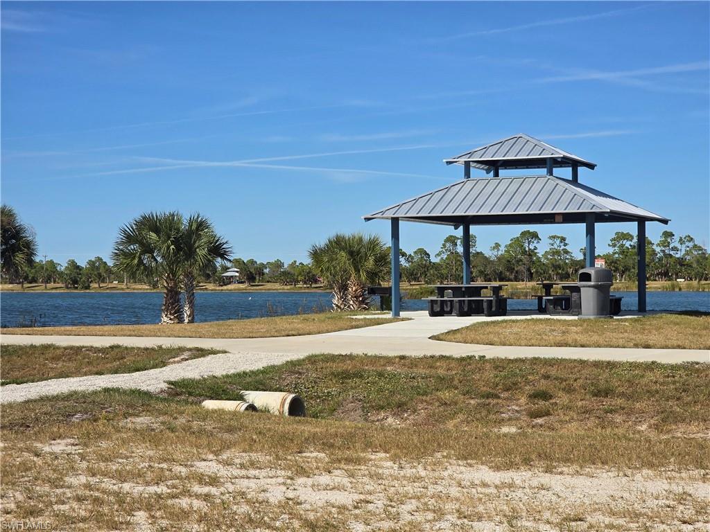 Image 4: Surrounding community with a gazebo, a water view, a patio, and a lawn