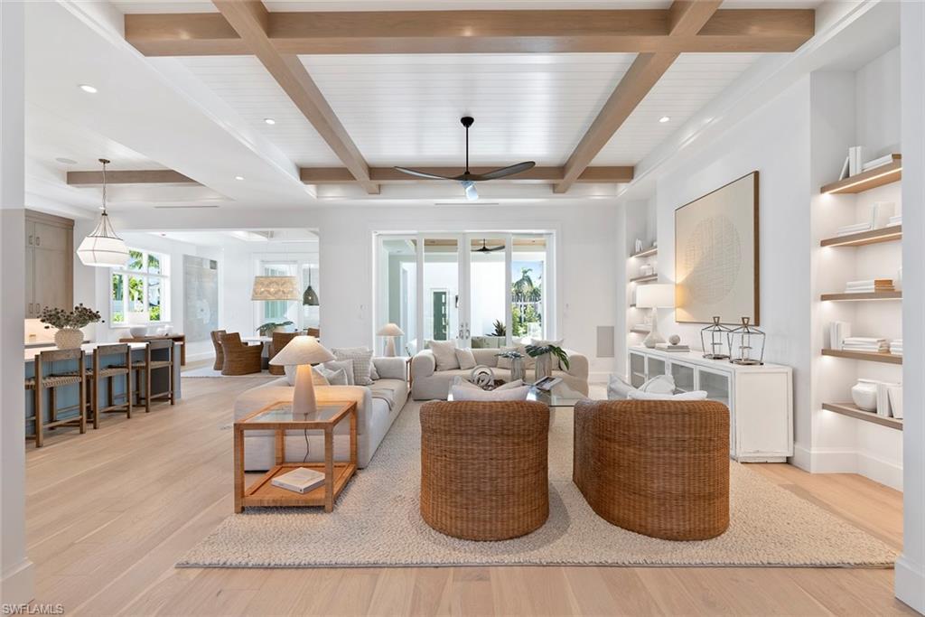 Image 2: Living area featuring plenty of natural light, light wood-style flooring, beamed ceiling, and a ceiling fan