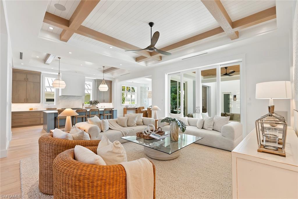 Image 3: Living room with beam ceiling, a ceiling fan, and light wood-style floors