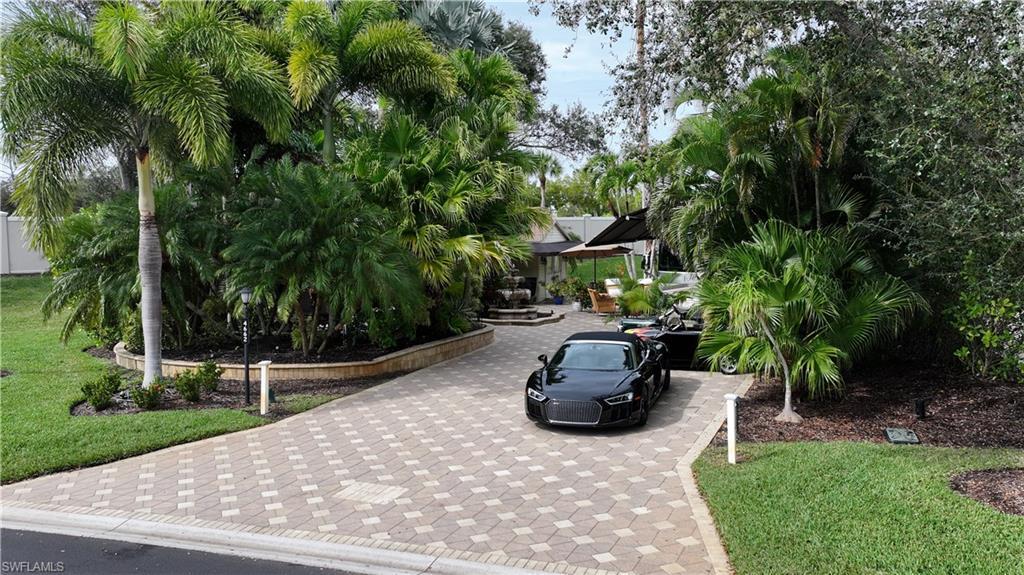 Image 4: Surrounding community with a lawn, a patio, and decorative driveway