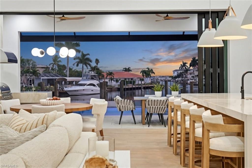 Image 3: Living area featuring ceiling fan, wood finished floors, and a water view