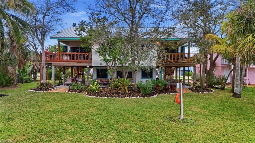 Image 4: Rear view of house featuring a lawn and a deck - Virtually Edited Image