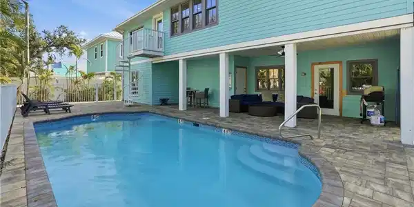 Image 3: View of pool with outdoor lounge area, a patio, a grill, and a balcony
