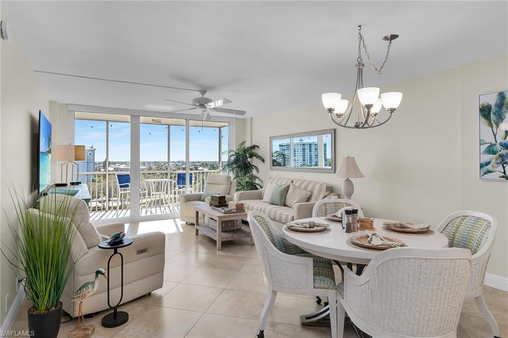 Image 3: Dining room featuring a ceiling fan, expansive windows, hanging lights, and light tile patterned floors