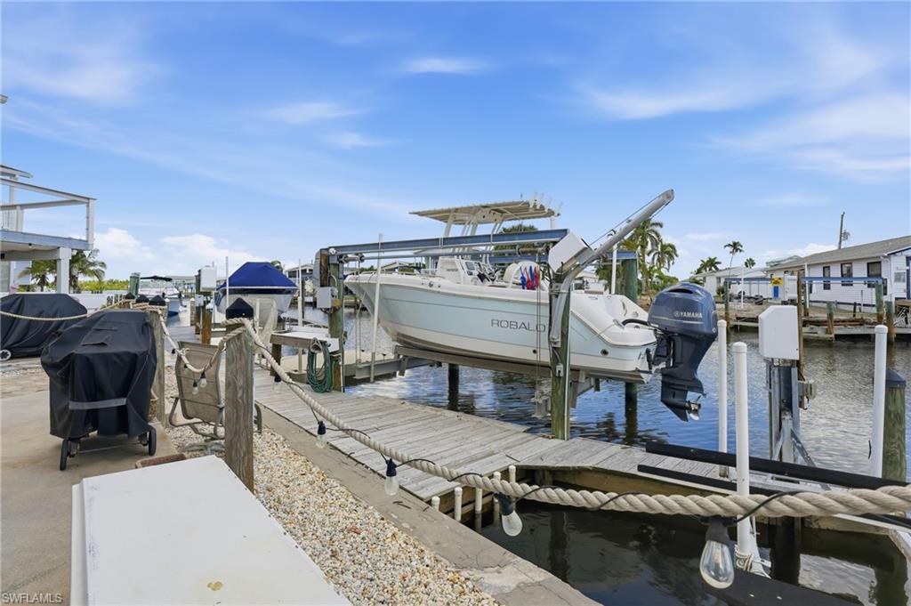 Image 3: Dock featuring boat lift and a water view