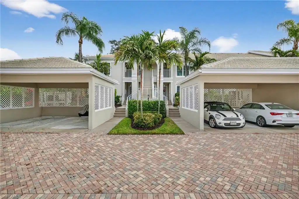 Image 1: View of front of home with stucco siding and a tile roof