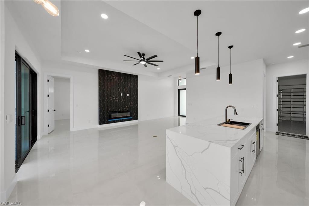 Image 4: Kitchen featuring appliances with stainless steel finishes, backsplash, a chandelier, white cabinetry, and recessed lighting