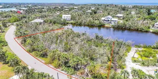 Image 2: Aerial view of property and surrounding area featuring a large body of water and property boundaries highlighted