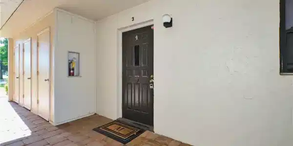 Image 3: Doorway to property with stucco siding