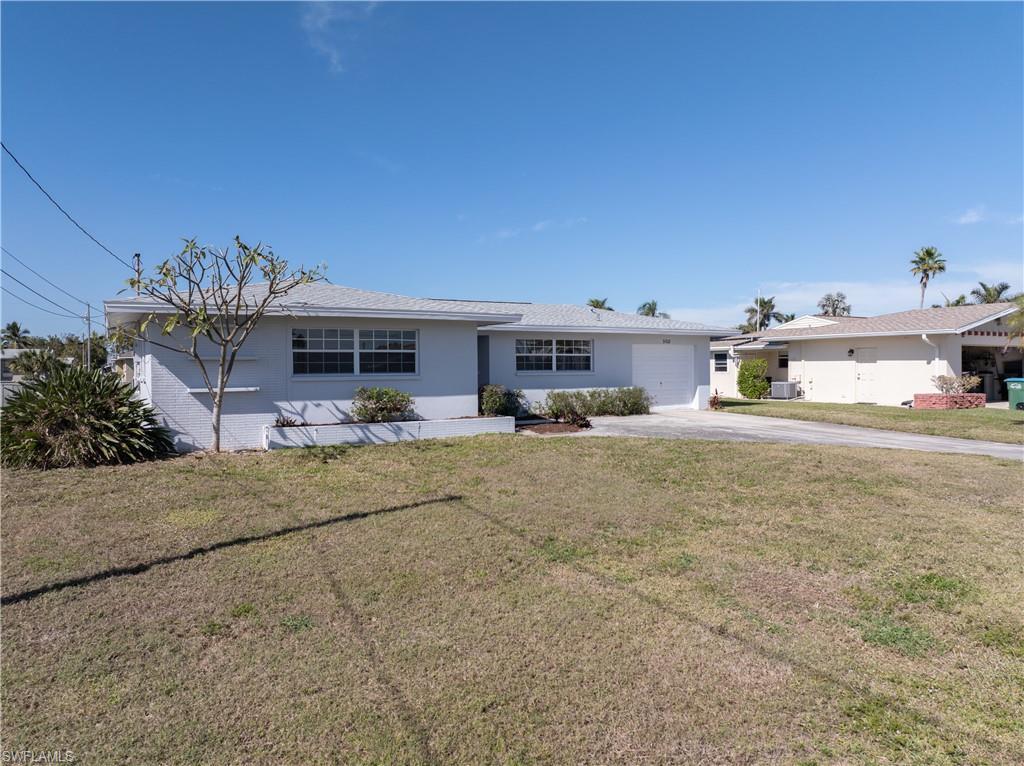 Image 1: Ranch-style house with cooling unit, a garage, and a front lawn