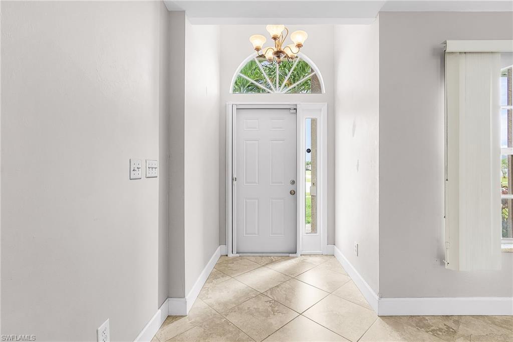 Image 2: Foyer with a chandelier and light tile patterned flooring