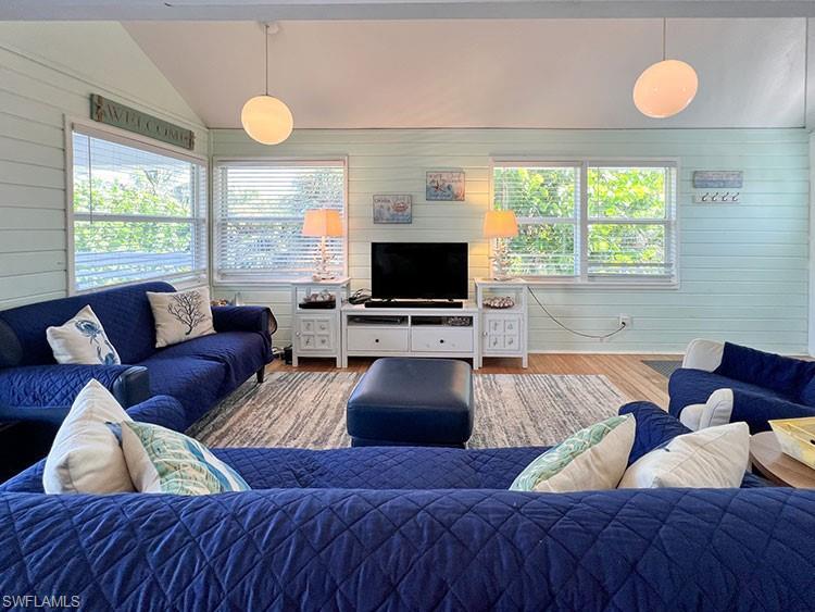 Image 4: Living room with vaulted ceiling and hardwood / wood-style floors
