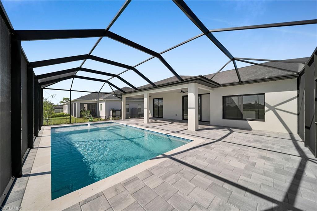 Image 4: Swimming pool featuring a sunroom, ceiling fan, glass enclosure, and a patio