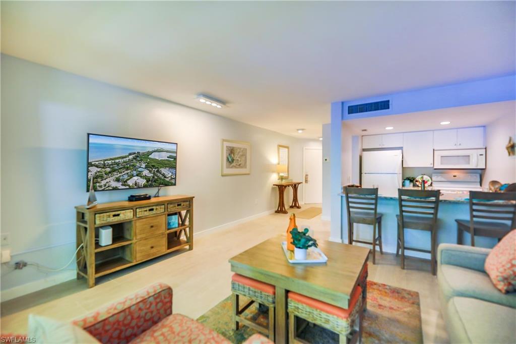 Image 4: Living area with light wood finished floors and recessed lighting