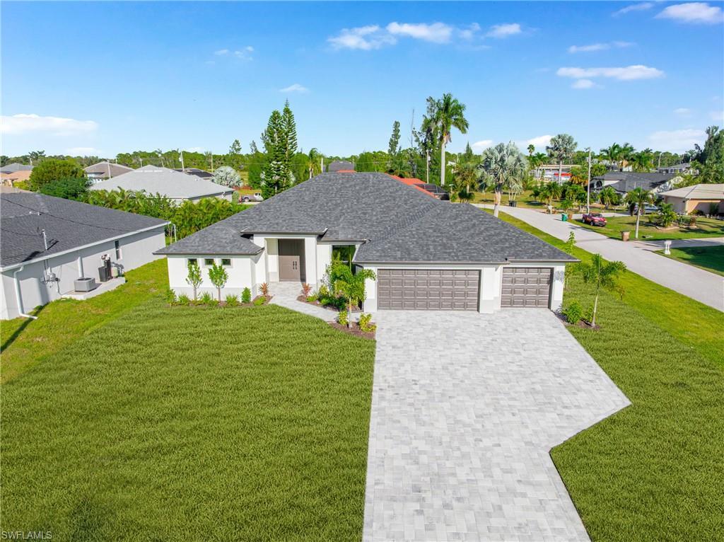 Image 3: View of front of house with a residential view, a front lawn, decorative driveway, roof with shingles, and a garage