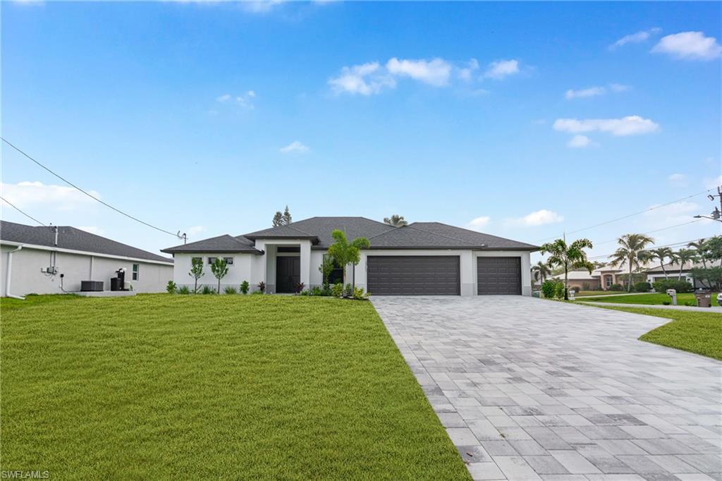 Image 4: Prairie-style house with a front yard, a garage, decorative driveway, and stucco siding