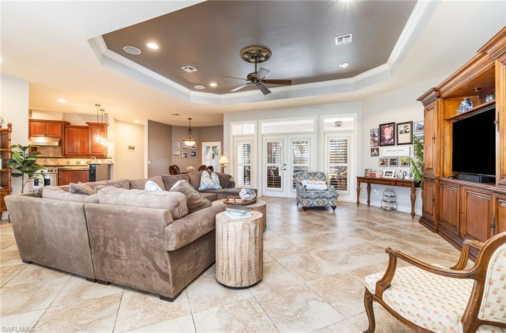 Image 2: Living area featuring recessed lighting, ceiling fan, a raised ceiling, ornamental molding, and light tile patterned floors