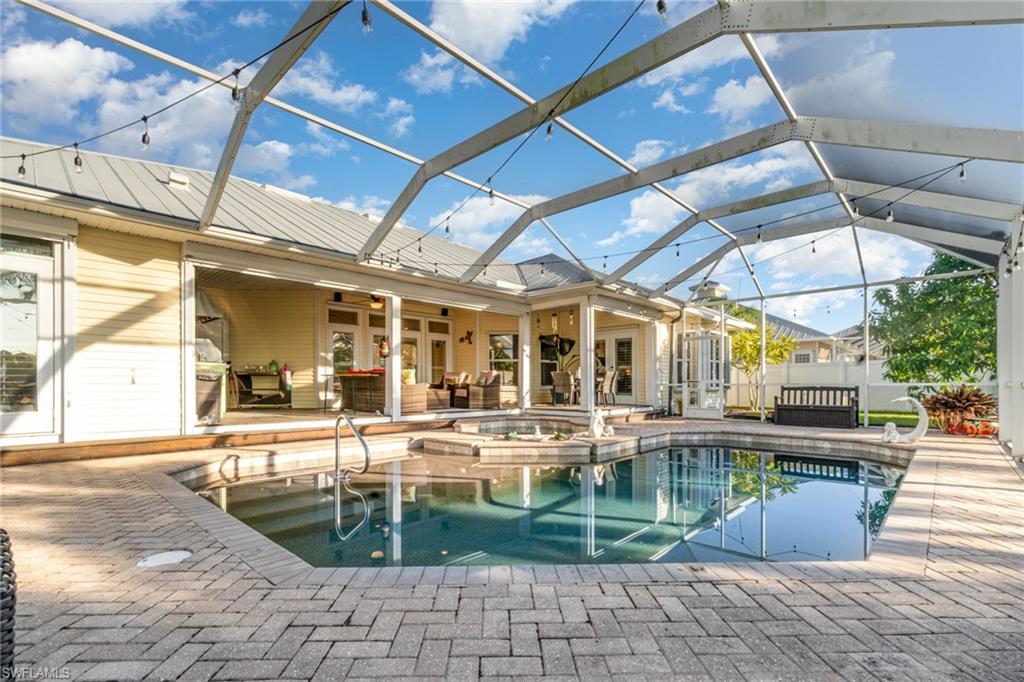 Image 4: View of pool with an outdoor hangout area, a patio area, glass enclosure, a sunroom, and french doors