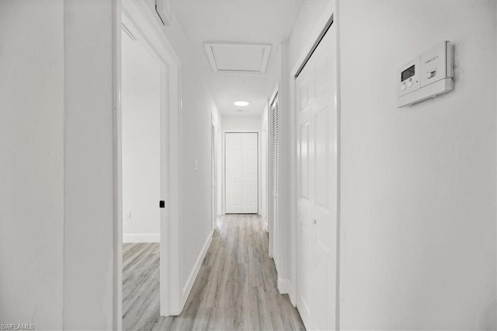 Image 3: Corridor with light wood-style flooring and attic access