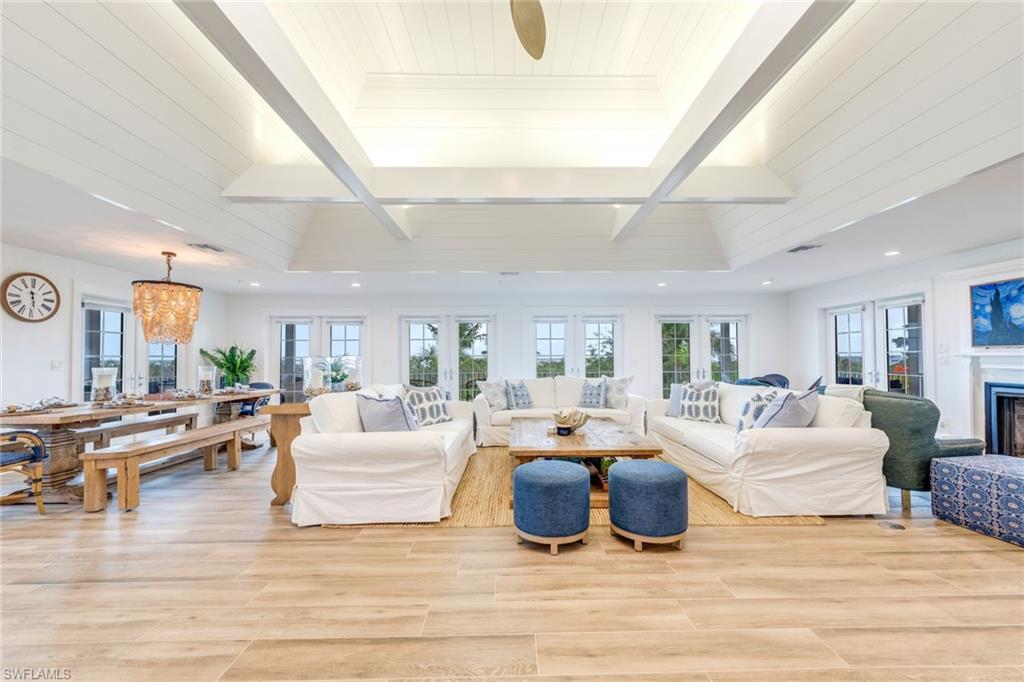 Image 4: Living area with healthy amount of natural light, light wood finished floors, a fireplace, and beamed ceiling