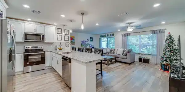 Image 4: Kitchen with stainless steel appliances, a peninsula, a kitchen breakfast bar, white cabinets, and recessed lighting