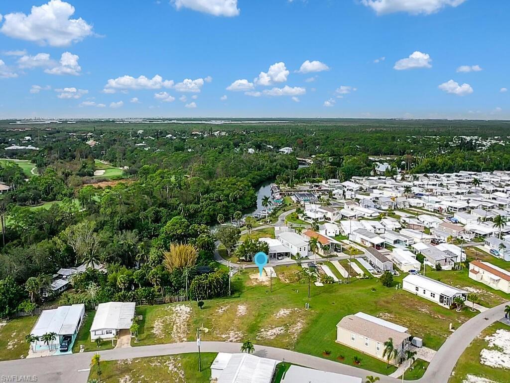 Image 2: Aerial view of property and surrounding area featuring nearby suburban area and a heavily wooded area