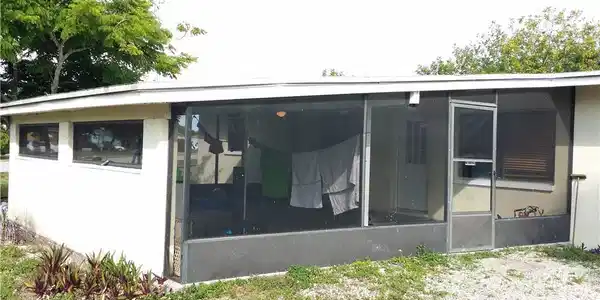 Image 2: Rear view of house with a sunroom