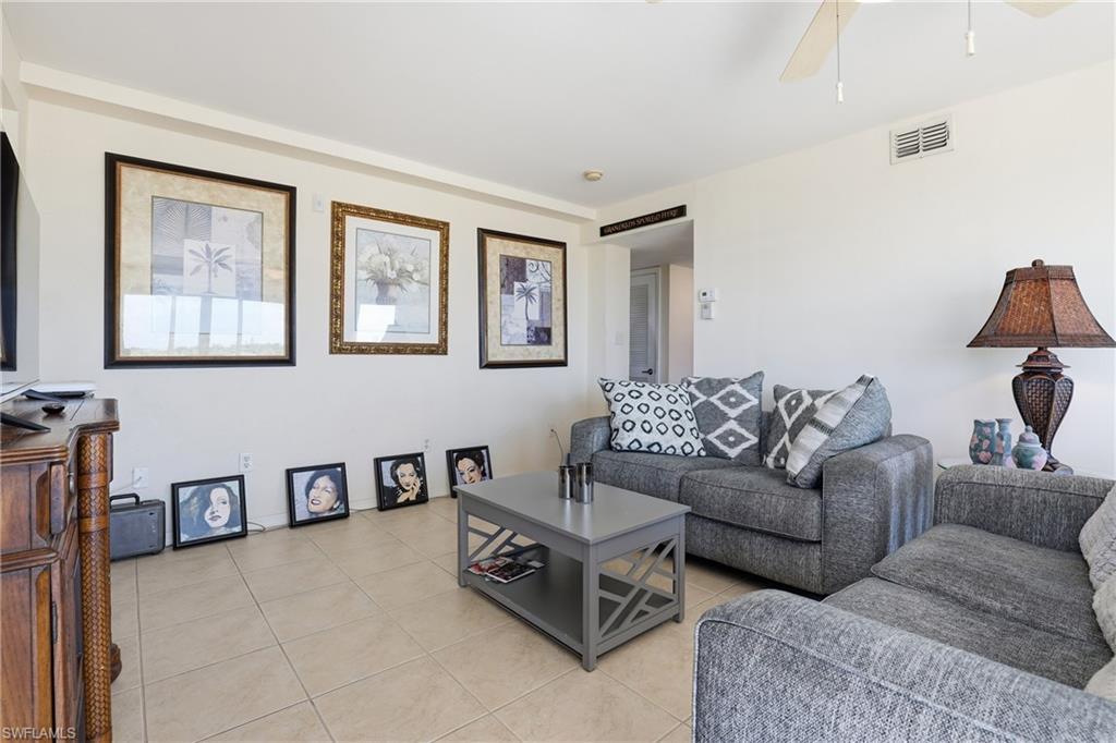 Image 4: Living room with light tile patterned floors and a ceiling fan