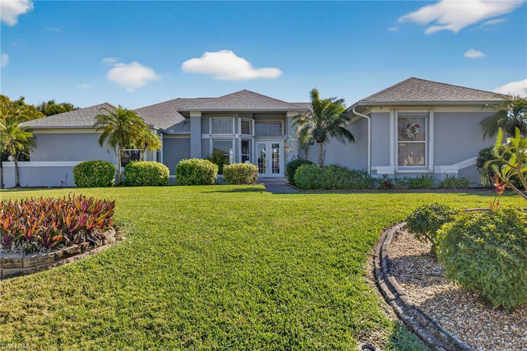 Image 1: Ranch-style home with french doors, stucco siding, a front lawn, a shingled roof, and a balcony