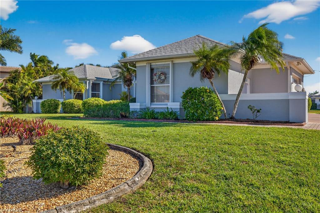 Image 2: View of front of property with stucco siding and a front yard