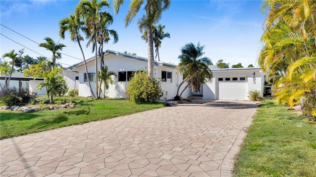 Image 2: Ranch-style home with a front yard, driveway, stucco siding, and a garage