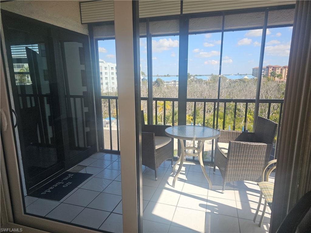 Image 3: Corner screened lanai with tile flooring and healthy amount of natural light accessible from both living area and primary bedroom via newly installed impact sliders
