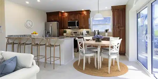 Image 2: Kitchen with a breakfast bar area, pendant lighting, stainless steel appliances, light stone countertops, and backsplash