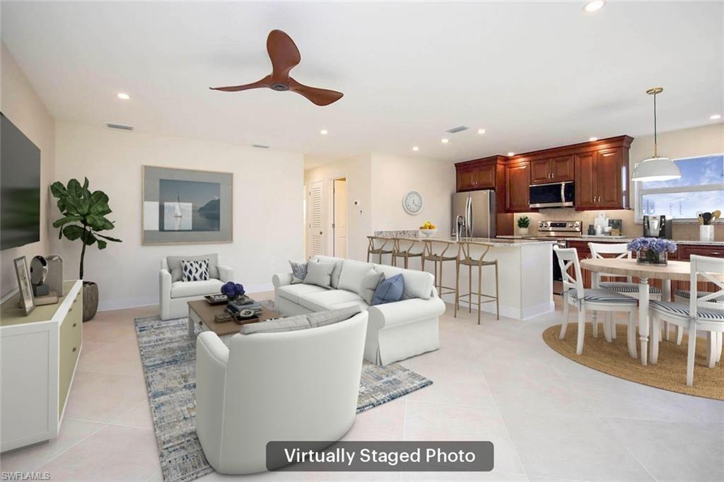 Image 3: Living room featuring light tile patterned floors and ceiling fan