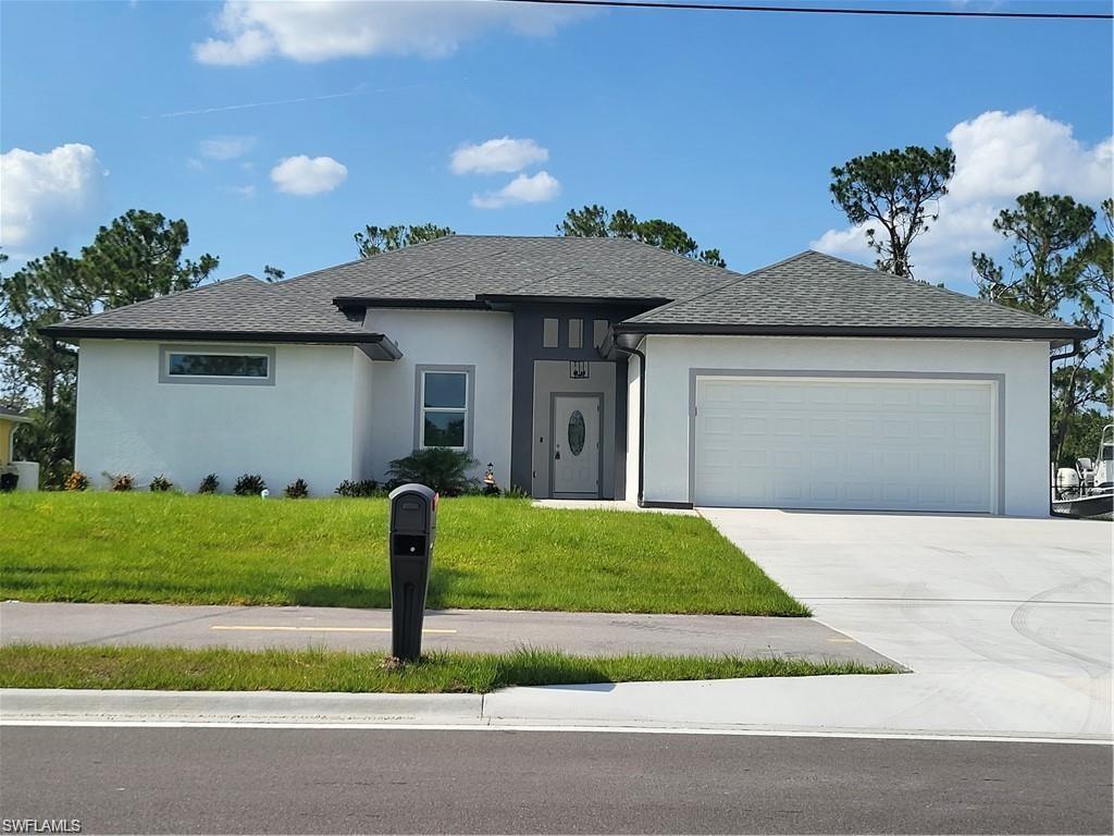Image 1: View of front of home featuring a garage and a front yard