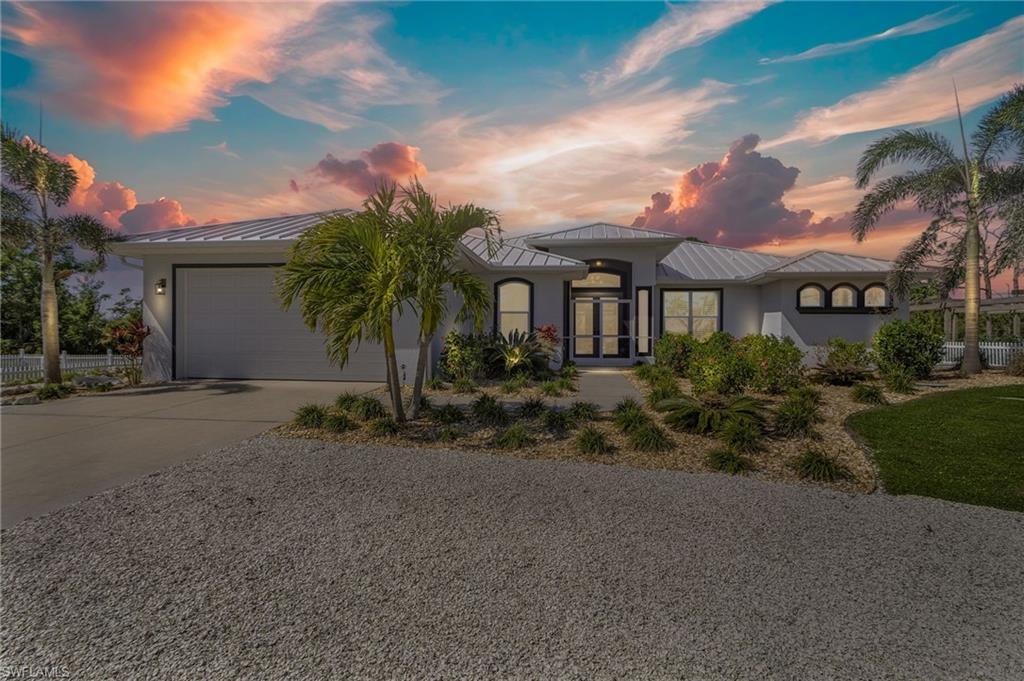 Image 2: View of front of house with a garage, concrete driveway, metal roof, a standing seam roof, and stucco siding