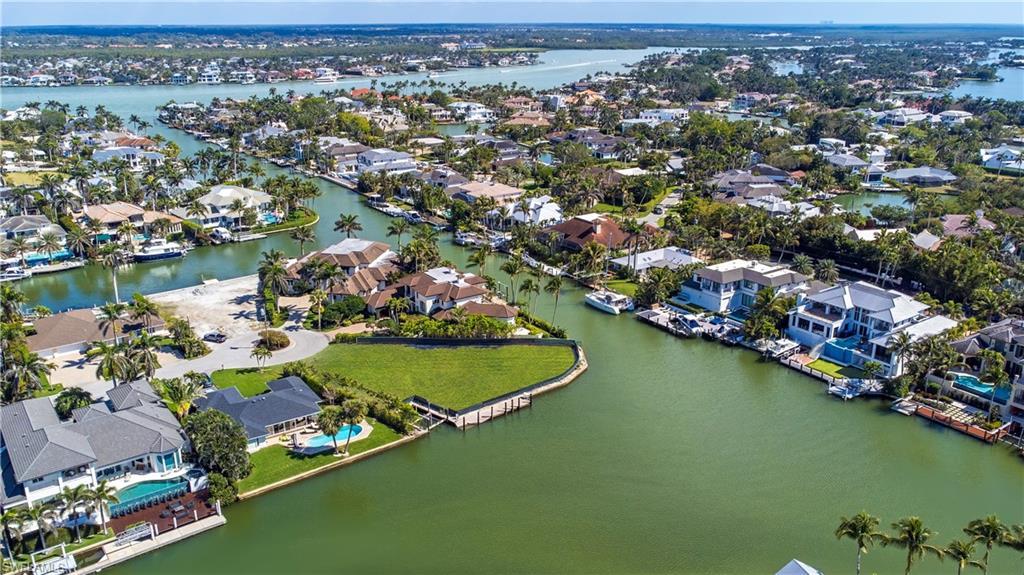 Image 4: Aerial view of residential area featuring a nearby body of water