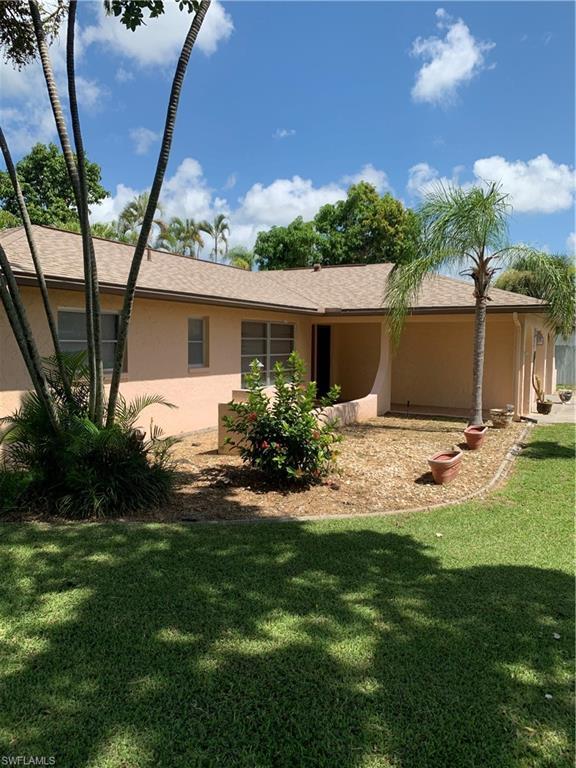 Image 2: Back of property with stucco siding and a lawn