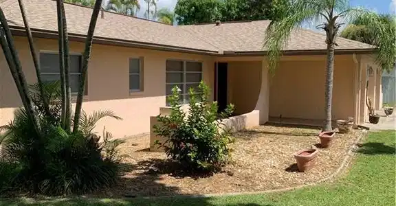 Image 2: Back of property with stucco siding and a lawn