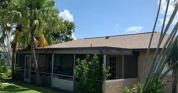 Image 4: Back of house with stucco siding, a shingled roof, a yard, and a sunroom
