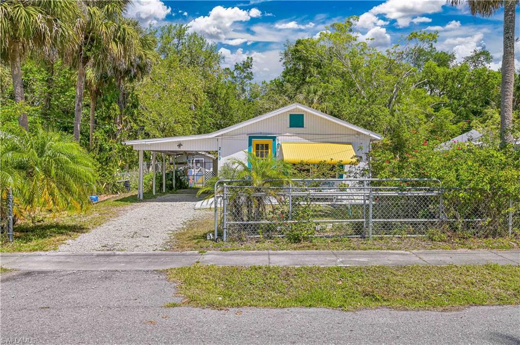 Image 2: View of front of home with driveway and fence
