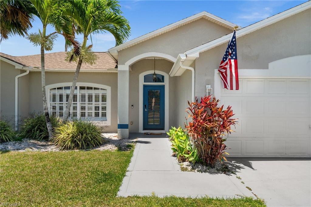 Image 1: Doorway to property featuring a garage, stucco siding, and a shingled roof