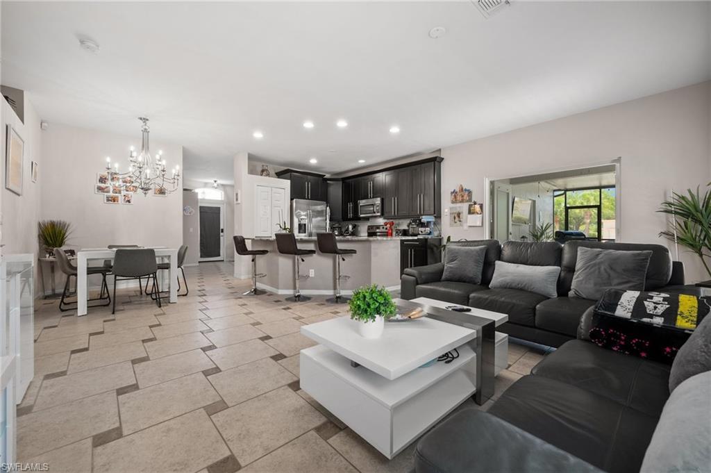 Image 3: Living room with a chandelier and recessed lighting