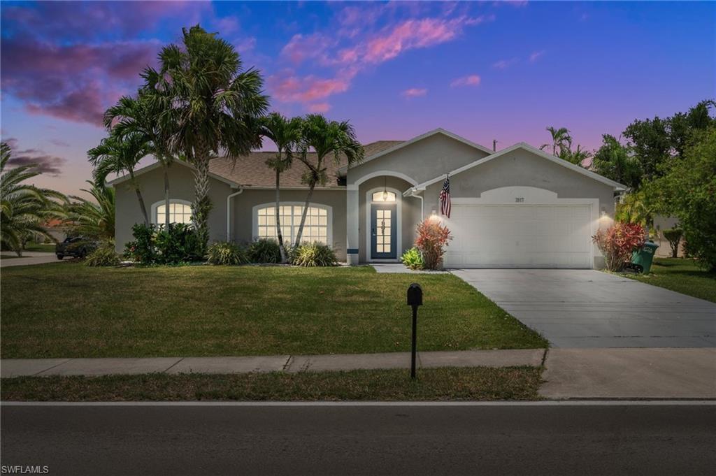 Image 4: Ranch-style home with stucco siding, an attached garage, a yard, and concrete driveway