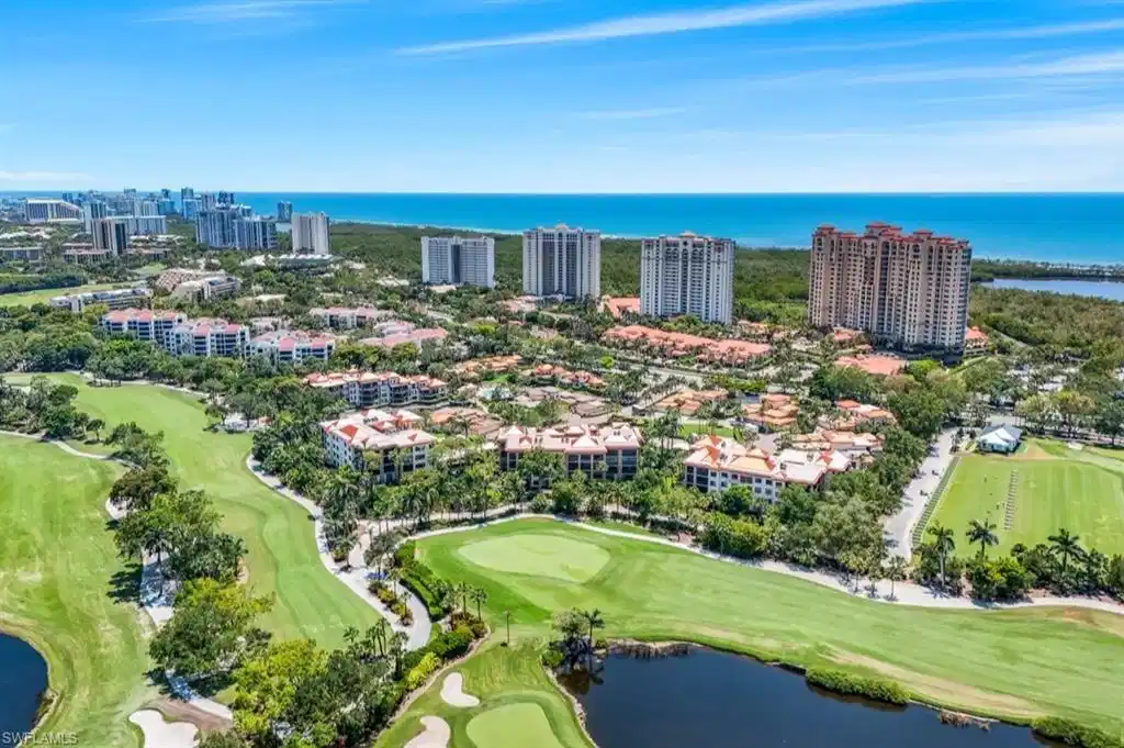 Image 1: Drone / aerial view of a nearby body of water, a golf club, and apartment complex / building