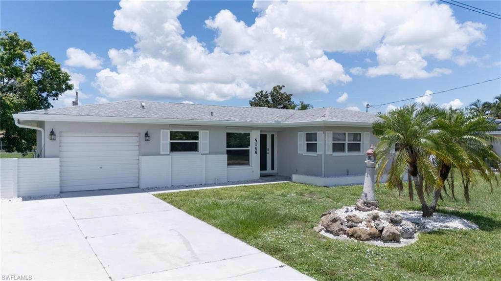 Image 1: Ranch-style house with concrete driveway, a garage, stucco siding, and a front lawn